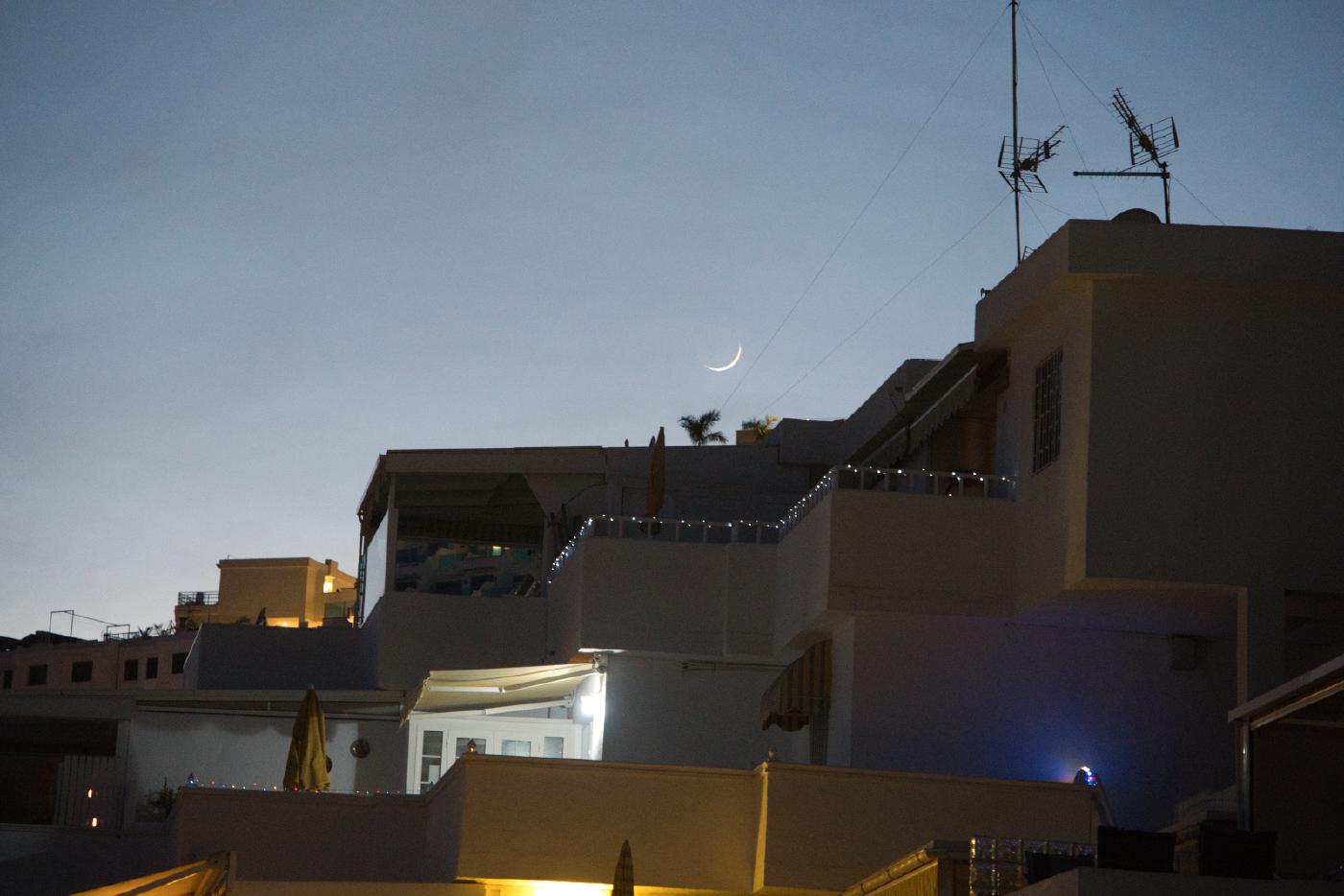 Young moon over the roof